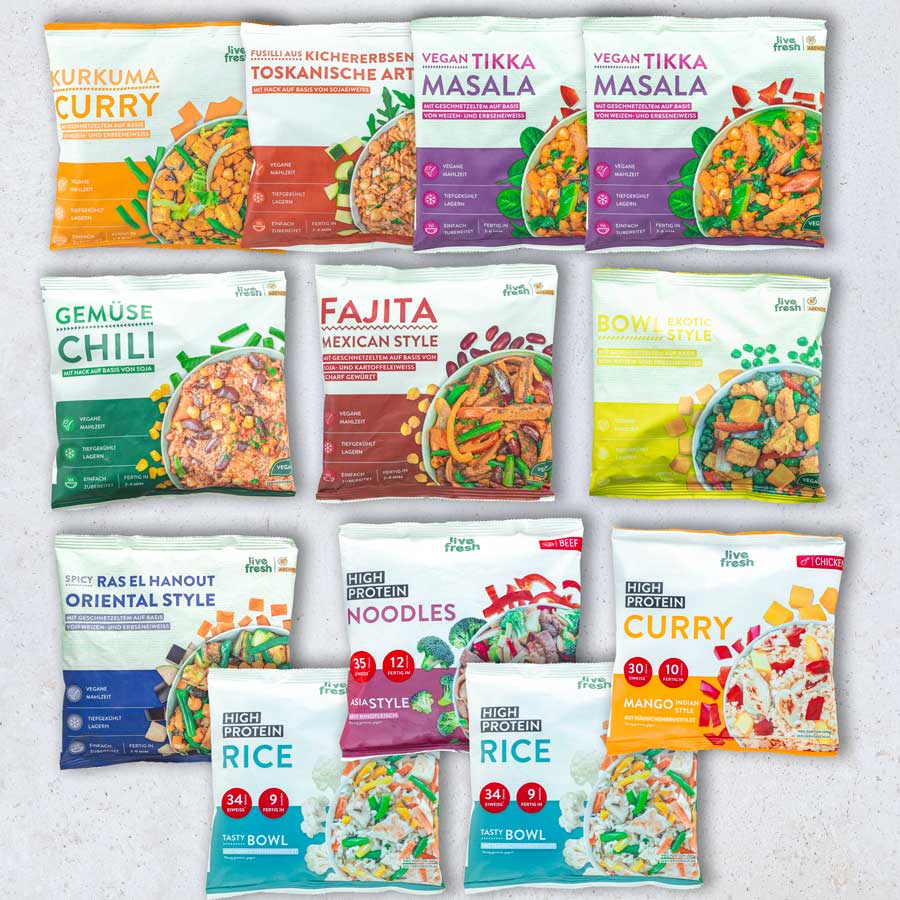 Zwölf verschiedene LiveFresh Tiefkühlgerichte nebeneinander aufgereiht, u.a. Kurkuma Curry, Gemüse Chili, Tikka Masala, Fajita, Ras el Hanout, Noodles und High Protein Rice Bowls. Die Gerichte sind farblich sortiert und zeigen eine Vielfalt an veganen und eiweißreichen Optionen.