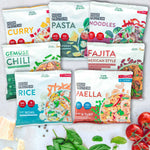 Auswahl an sieben LiveFresh High Protein Bowls in verschiedenen Sorten wie Curry, Pasta, Noodles, Gemüse Chili, Fajita, Rice und Paella, dekorativ angerichtet mit frischen Kräutern, Tomaten und Käse auf hellem Untergrund.