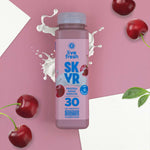 Flasche Live Fresh Skyr Protein Drink Kirsche auf rosa Hintergrund mit Kirschen und Milchspritzer.