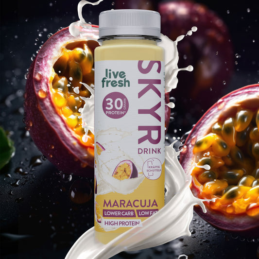 Nahaufnahme einer Flasche Skyr-Drink Maracuja von 'live fresh', umgeben von aufgeschnittenen Maracuja-Früchten. Auf der Flasche steht '30g Protein', 'lower carb, low fat, high protein' und 'kräftig schütteln'. Weiße Spritzer symbolisieren die cremige Konsistenz des Drinks.